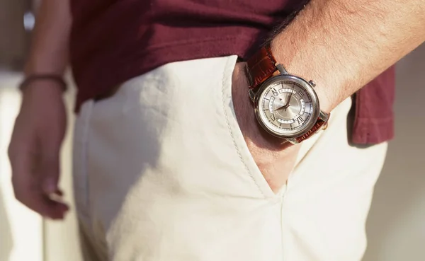 Zbliżenie moda obraz luksusowe zegarki na rękę man.body szczegółami działalności człowieka. Ręka mężczyzny w znudzony t-shirt w kolorze beżowym spodnie kieszeń zbliżenie. Dorywczo strój. Korekta tonalna — Zdjęcie stockowe