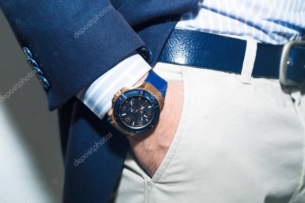 Men suit perfect to the last detail.Man posing in blue suit.Businessman standing.Handsome elegant young fashion man in coat tuxedo classical costume .Hand in pocket with wrist watch in business suit.