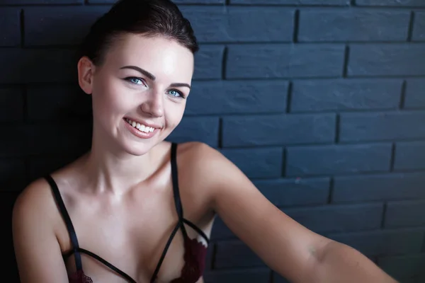 Портрет красавицы. Smiling young woman on black wall background.Indoor portrait of beautiful brunette young woman, smiling cheerfully, showing her white teeth to camera happy — стоковое фото