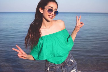 Giyen vintage güneş gözlüğü ve kıyafet, tatil tarzı mutlu gülen kadın plajda, yaşam tarzı portresi kadar kapatın.