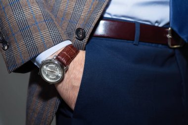 Bir iş adamı man.body ayrıntı lüks seyretmek üstünde kol bileği closeup moda görüntüsü. Koyu mavi kareli ceketi giyen erkek eli cebinde closeup pantolon. Casual kıyafet. Kadar yakın iş elbiseli ton