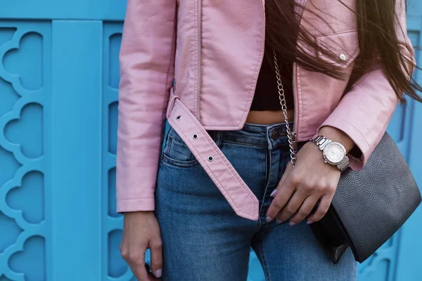 Close-up fashion portrait of young stylish hipster girl posing at city street,stylish woman's look,pink leather jacket,jeans,watches,toned colors,soft vintage — Stock Photo, Image