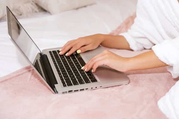 Nő használ laptop az ágyára. Nő használ számítógép, Home.woman felzárkózását a szociális média, mint ő ellazítja az ágyban laptop számítógép egy lusta nap — Stock Fotó
