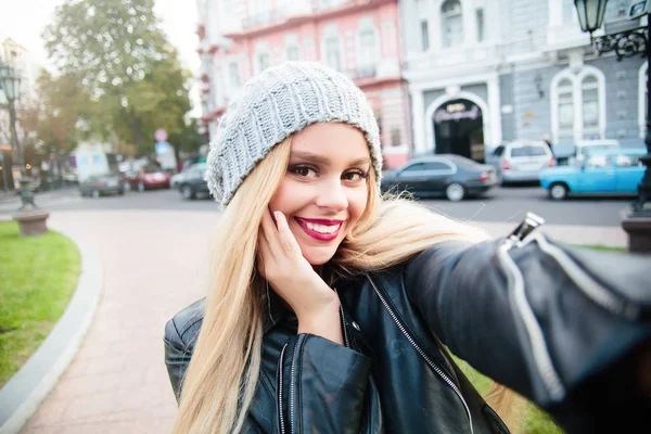 Joven chica sonriente haciendo selfie en el fondo de la ciudad.mujer tomando foto autorretrato selfie en los viajes de Europa. Feliz turista cándido. Chica bonita eufórica haciendo selfie mientras da un paseo. — Foto de Stock