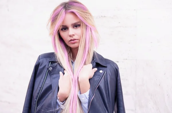 Hermosa modelo de moda hipster con el pelo rizado de color rosa posando en la pared urbana.Una hermosa chica con el pelo púrpura camina por las calles de la ciudad.Llevar una chaqueta, camisa de jean rasgada. — Foto de Stock