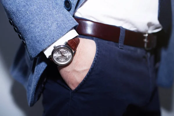 Closeup fashion image of luxury watch on wrist of man.body detail of a business man.Man's hand in wool blue jacket,in dark blue pants pocket closeup.Casual outfit. Tonal in a business suit close up — Stock Photo, Image