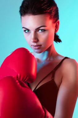 moda stüdyo spor eldiven boks için koyu saçlı seksi güzel kadın fotoğrafı. Kameraya renk arka plan üzerinde seyir bloxing eldiven kızla genç fitness