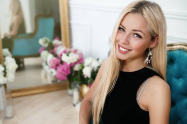 Çiçekli renkli arka plan üzerinde poz güzel siyah elbiseli güzel genç kadın. Moda fotoğraf, saçların çok güzel, gülümseyin, genç güzel başarılı kadın kamera için arıyorsunuz