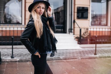 Yakın çekim moda kadın portresi deri ceket, geniş şapka, eşarp ve kazak giyen genç oldukça trendy kız Avrupa, Bahar sokak moda, şehirde, poz gülen ve portrait.trendy gülümseyen
