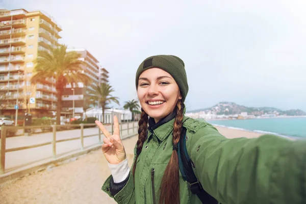 かなり若い女性観光客は Spain Beautiful 若い旅行ブロガー春休暇バルセロナ中ビーチで旅行 Selfie を取ります Selfie と笑顔を幸せな少女の日当たりの良い肖像画を間近します — ストック写真