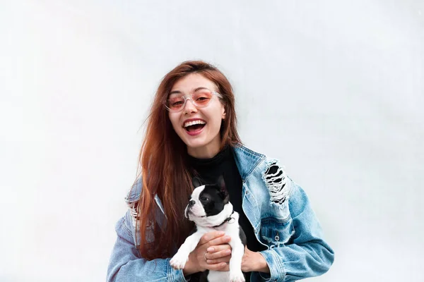 Woman Love Pet Dog.Cheerful pretty young woman in jeans coat, hugging her dog.pretty woman beautiful young happy with long dark hair holding small dog puppy boston  terrier.White background.Copy space