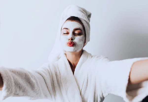 아름다운 여성의 셀카닫기 머리에 수건을 샤워를 얼굴에 크림을 키스를 마스크를 — 스톡 사진