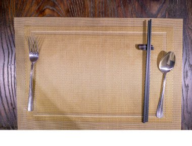 Ahşap yemek çubuğu, gümüş kaşık ve masa örtüsü üzerinde yaşayan insanlar.