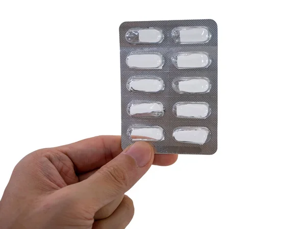 Beyaz arkaplanda el ele tutuşan boş bir hap paketi var.