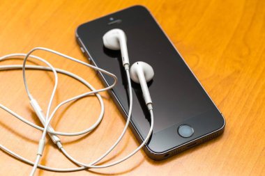 Ahşap masanın üzerinde yatan beyaz kulaklık