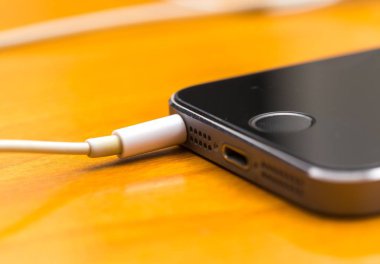 Ahşap masanın üzerinde yatan beyaz kulaklık