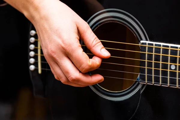 女人的手和黑色的声学吉他 — 图库照片