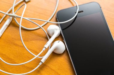 Ahşap masanın üzerinde yatan beyaz kulaklık