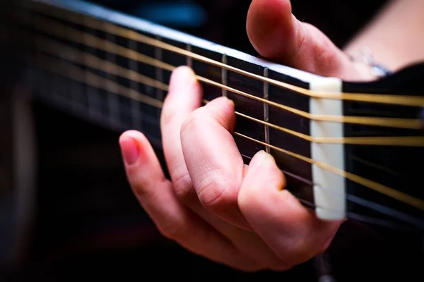 Manos de mujer y guita acústica negra — Foto de Stock