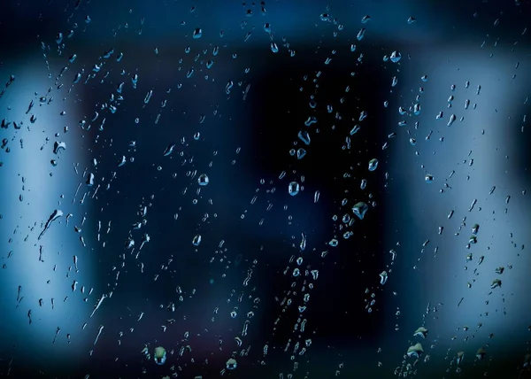 Капли воды на окне в тёмный осенний дождливый день — стоковое фото