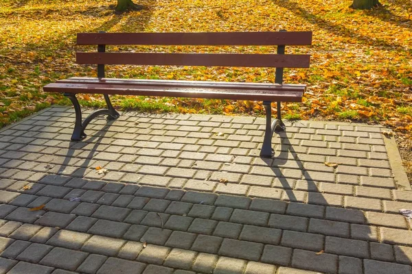 Bank im herbstlichen Park in kleiner polnischer Stadt — Stockfoto