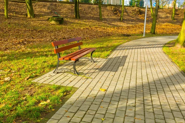 Скамейка в осеннем парке в маленьком польском городе — стоковое фото