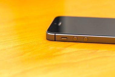 Ahşap masanın üzerinde yatan cep telefonu kapatın