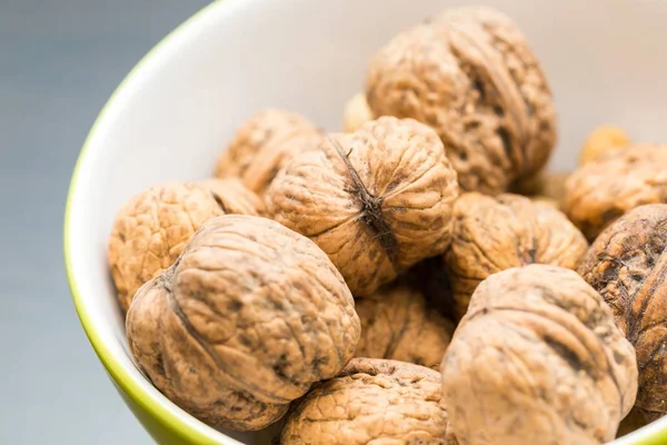 Walnuts in green ceramic bowl in close up. — Stock Photo, Image