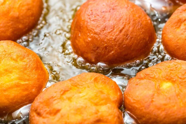 Donuts frying in deep fat — Stock Photo, Image