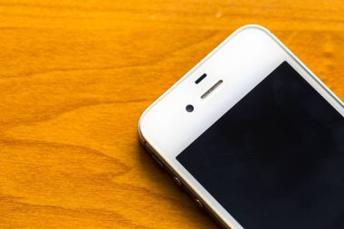 Ahşap masanın üzerinde yatan cep telefonu kapatın
