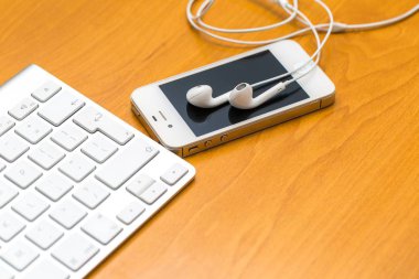 Ahşap masanın üzerinde yatan beyaz kulaklık