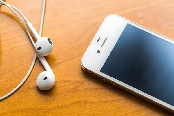 Casque blanc couché sur une table en bois — Photo