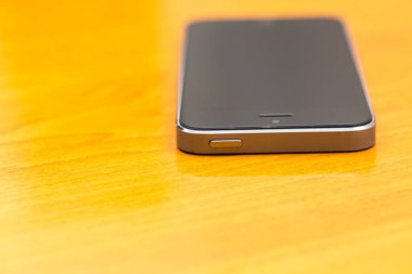 Ahşap masanın üzerinde yatan cep telefonu kapatın