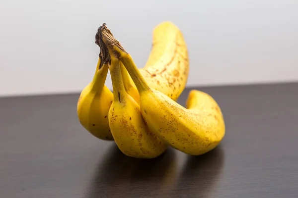 Bunch of bananas lying on dark wooden table — Stock Photo, Image