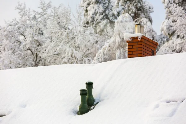 Крыша дома с дымоходом в снежный зимний день — стоковое фото