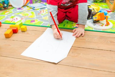 Küçük çocuk beyaz kağıt üzerine kalemle çizim