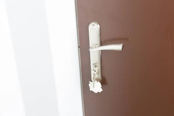 Close up of doorhandle, key and door in home — Stock Photo, Image