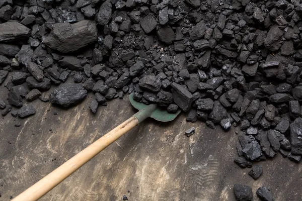 Carvão preto e pá deitada em uma pilha no porão da casa — Fotografia de Stock