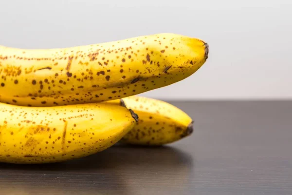 Bunch of bananas lying on dark wooden table — Stock Photo, Image