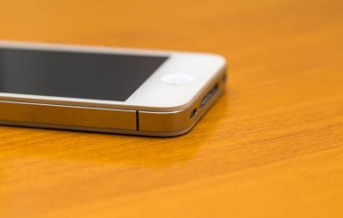 Ahşap masanın üzerinde yatan cep telefonu kapatın