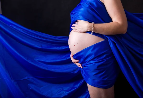 Kobieta w ciąży Yong w kolorowe tkaniny. — Zdjęcie stockowe
