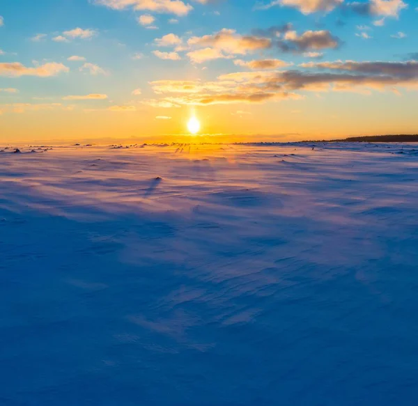 Západ slunce v zimě pole se sněhem pohybující se větrem — Stock fotografie