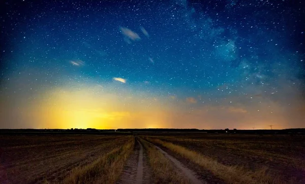 Cielo nocturno estrellado sobre un camino arenoso rural — Foto de Stock