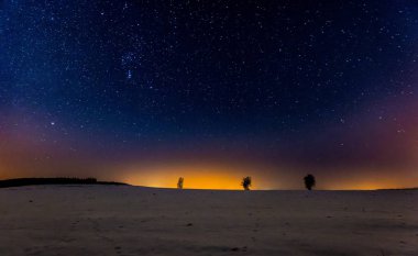 Kış karlı alanları üzerinde gece gökyüzü