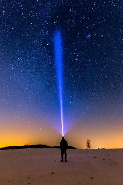 Stjärnhimmel och man med ficklampa. Natt vinterlandskap. — Stockfoto