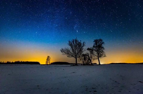 Milchstraße und Sternenhimmel über Winterlandschaft und fernem Dorf — Stockfoto