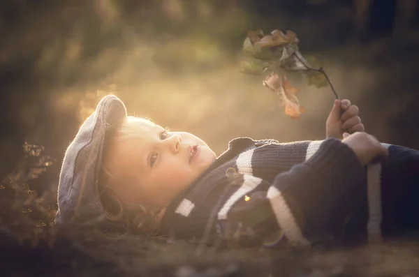 Menino brincando ao ar livre no outono cenário . — Fotografia de Stock