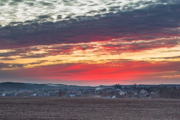 Pôr do sol céu colorido sobre aldeia polonesa na primavera — Fotografia de Stock