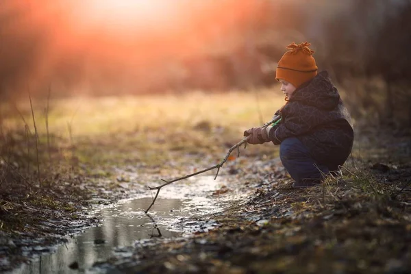 Μικρό αγόρι παίζει σε λακκούβα στο άνοιξη — Φωτογραφία Αρχείου