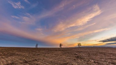 Bahar sürülmüş alana üzerinde güzel renkli günbatımı gökyüzü